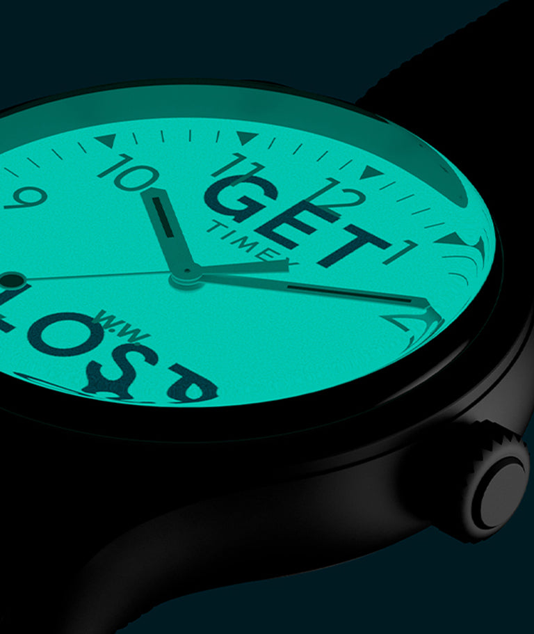 Up close of analog watch with the indiglo dial activated