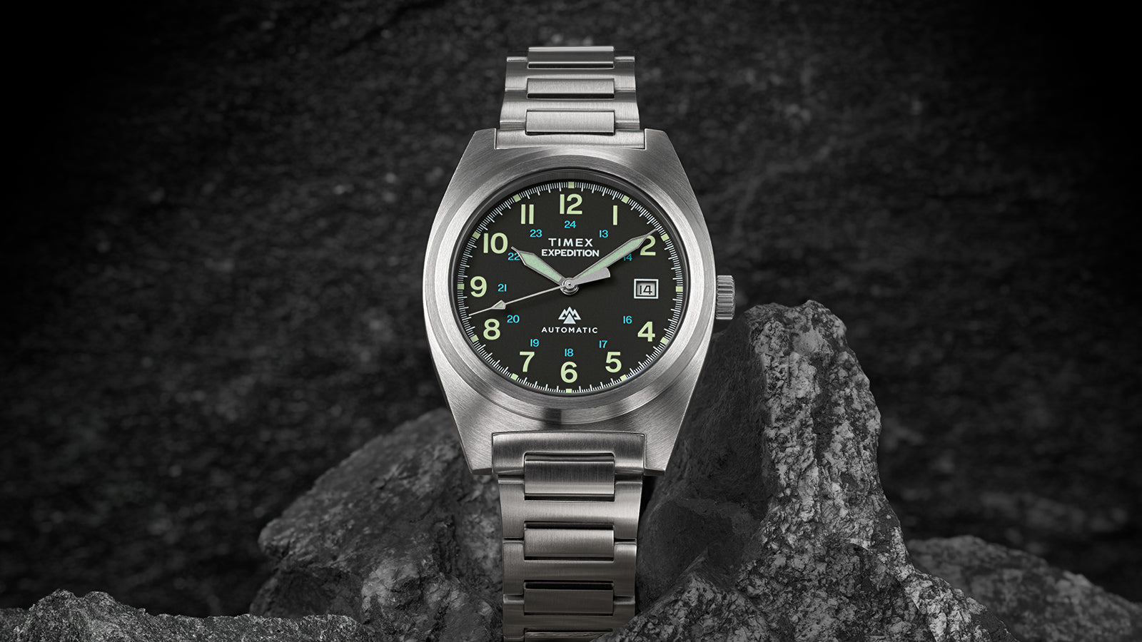 Front view of the Timex Expedition® Capstone Automatic watch highlighting its field-inspired design. The black dial with luminous green markers and brushed steel bezel conveys rugged style and precision engineering.