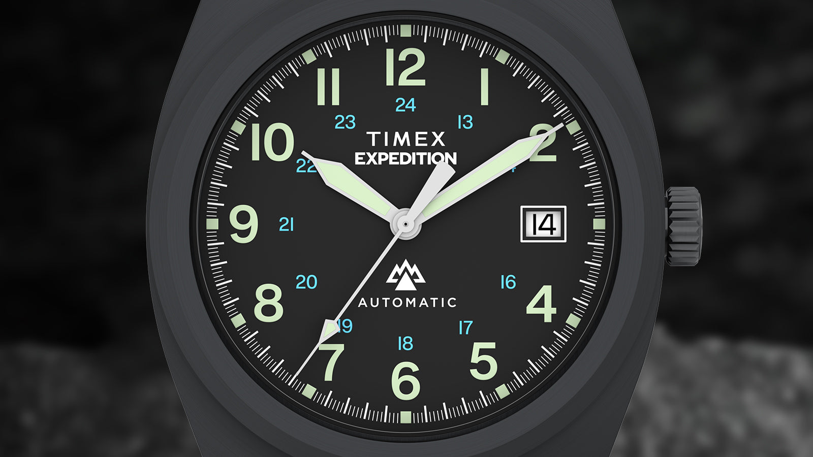 Close-up of the Timex Expedition® Capstone Automatic dial showcasing luminous green numerals, blue 24-hour markers, and glow-accented hands on a black background. A date window sits cleanly at 3 o’clock.