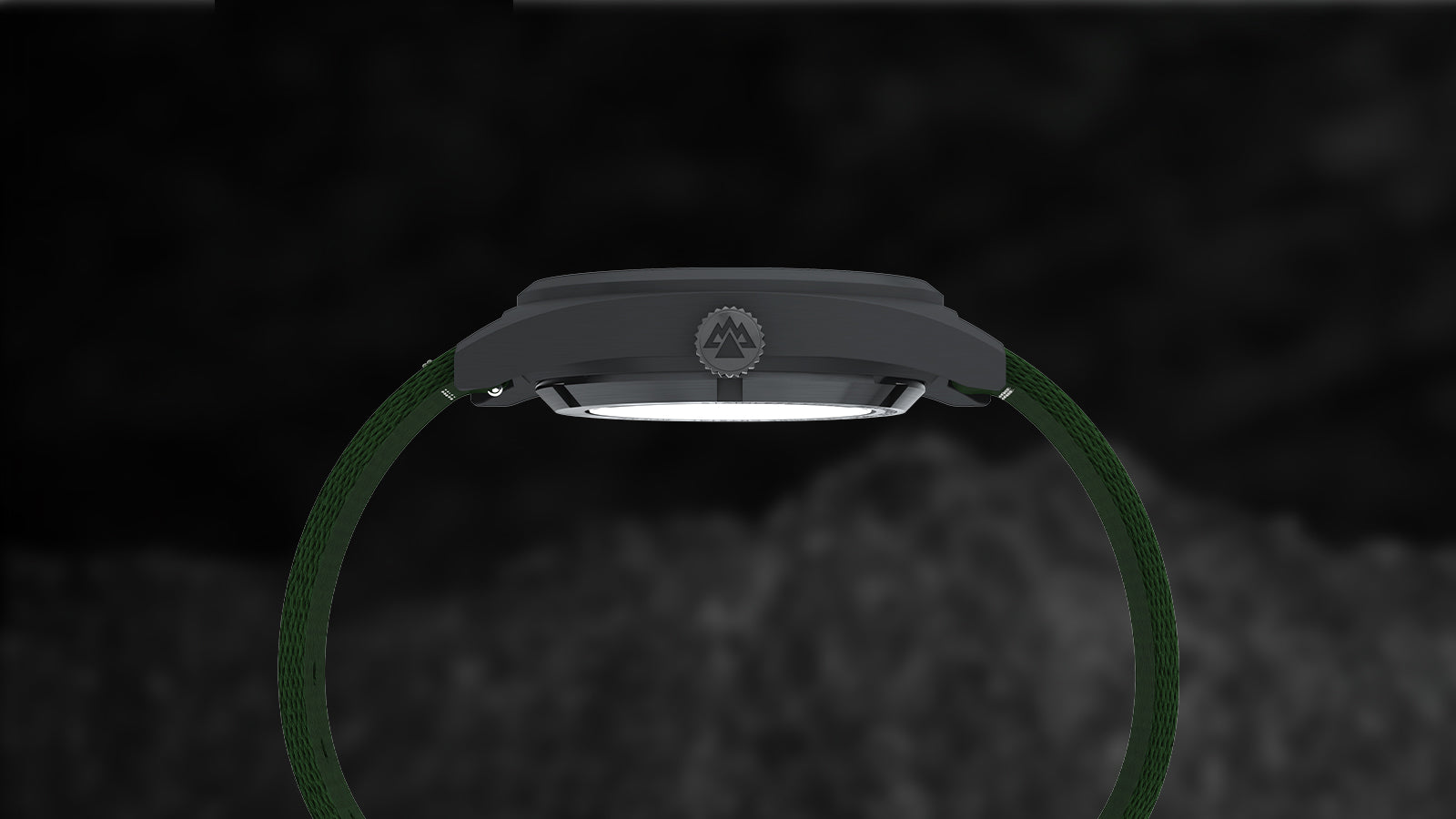 Side view of the Timex Expedition® Capstone Automatic showing its brushed gunmetal case, knurled crown with Expedition mountain logo, and durable green fabric strap, emphasizing its rugged build and sleek profile.