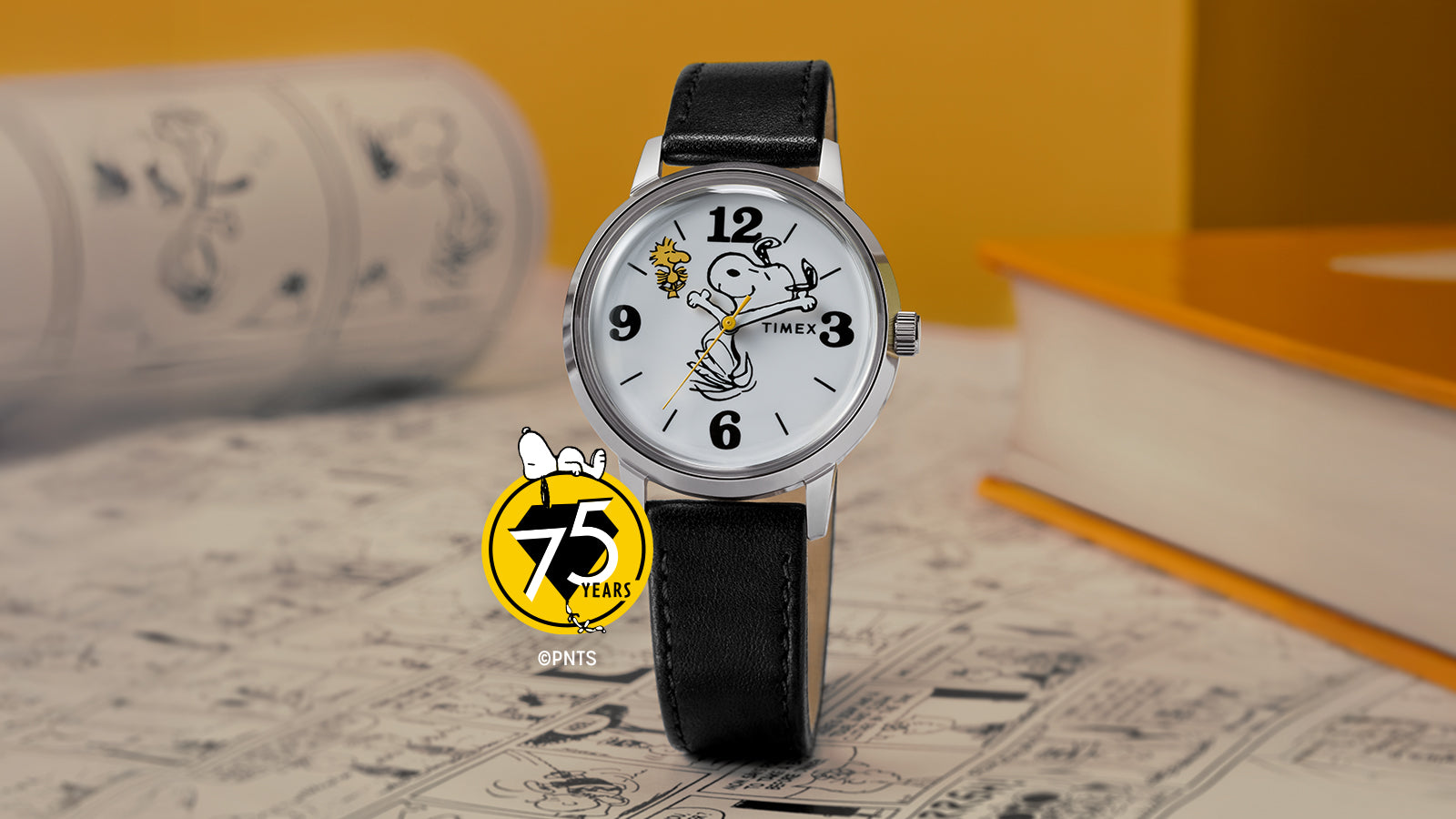 A Timex x Peanuts® Marlin® 75th Anniversary Edition watch with a white dial, black leather strap, and polished stainless-steel case displayed on a comic-themed background. The dial features Snoopy swinging a golf club with Woodstock flying nearby, and a yellow Peanuts 75 Years logo accent in the corner.