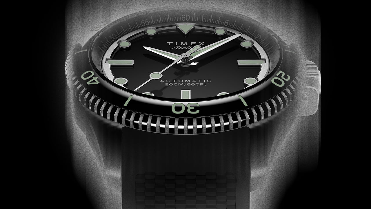 Front view of the Timex Atelier automatic dive watch with black dial, luminous indices, and black textured rubber strap, designed for mobile display.
