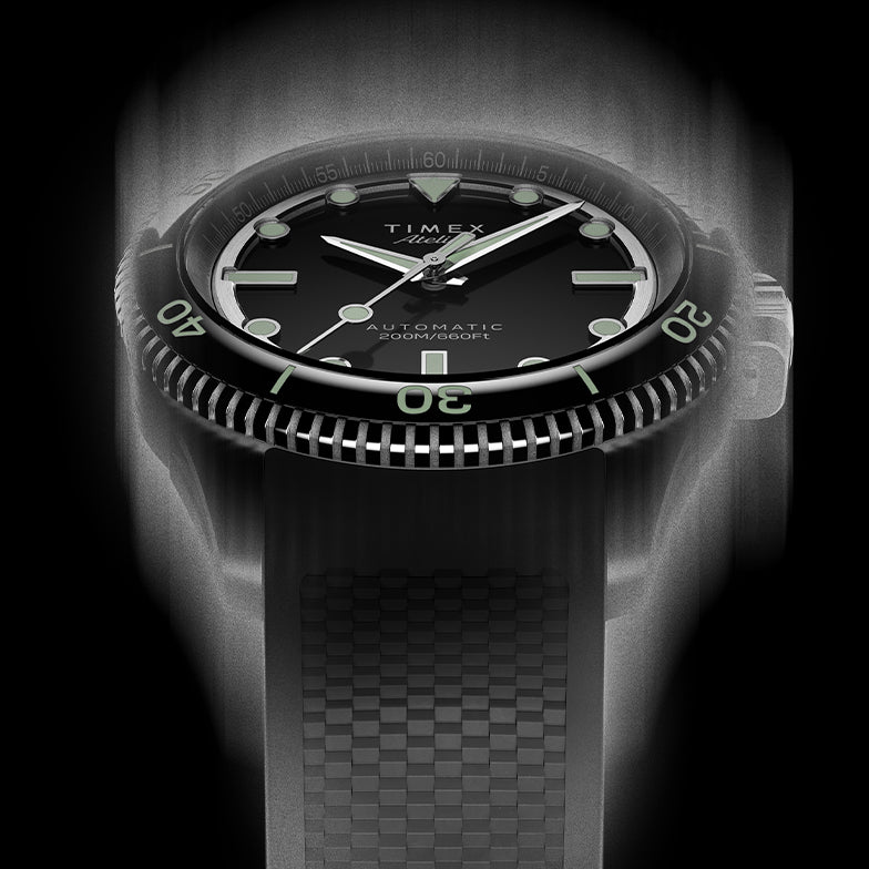 Front view of the Timex Atelier automatic dive watch with black dial, luminous indices, and black textured rubber strap, designed for mobile display.