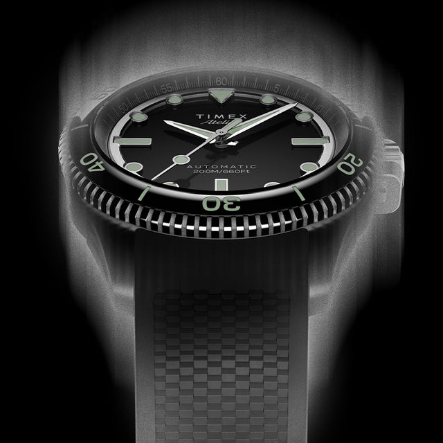 Front view of the Timex Atelier automatic dive watch with black dial, luminous indices, and black textured rubber strap, designed for mobile display.