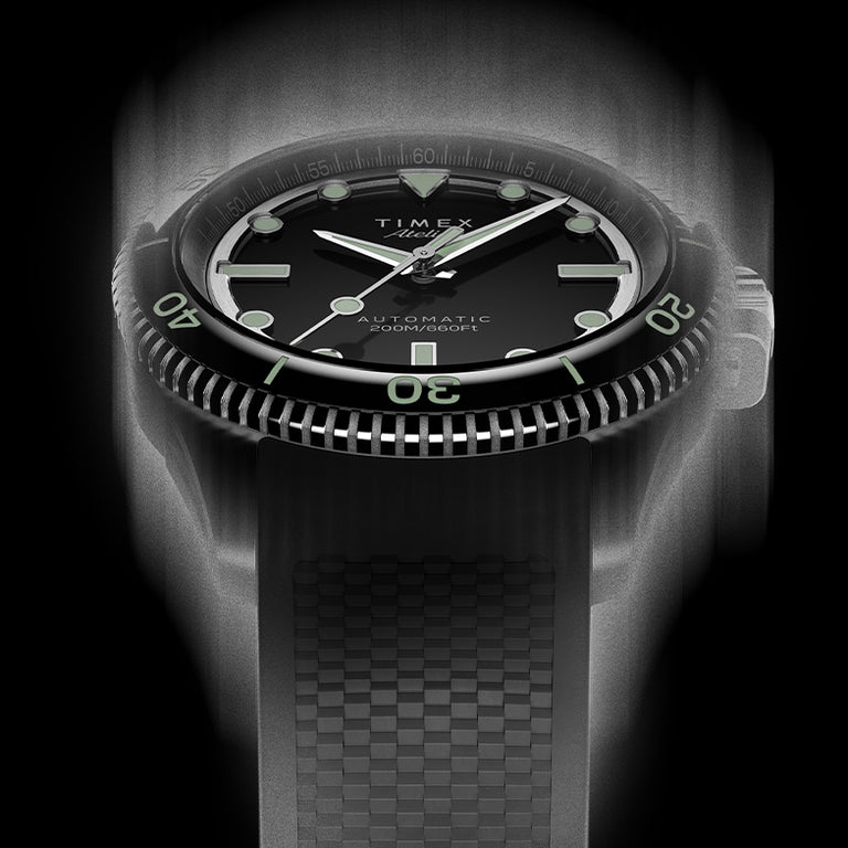 Front view of the Timex Atelier automatic dive watch with black dial, luminous indices, and black textured rubber strap, designed for mobile display.
