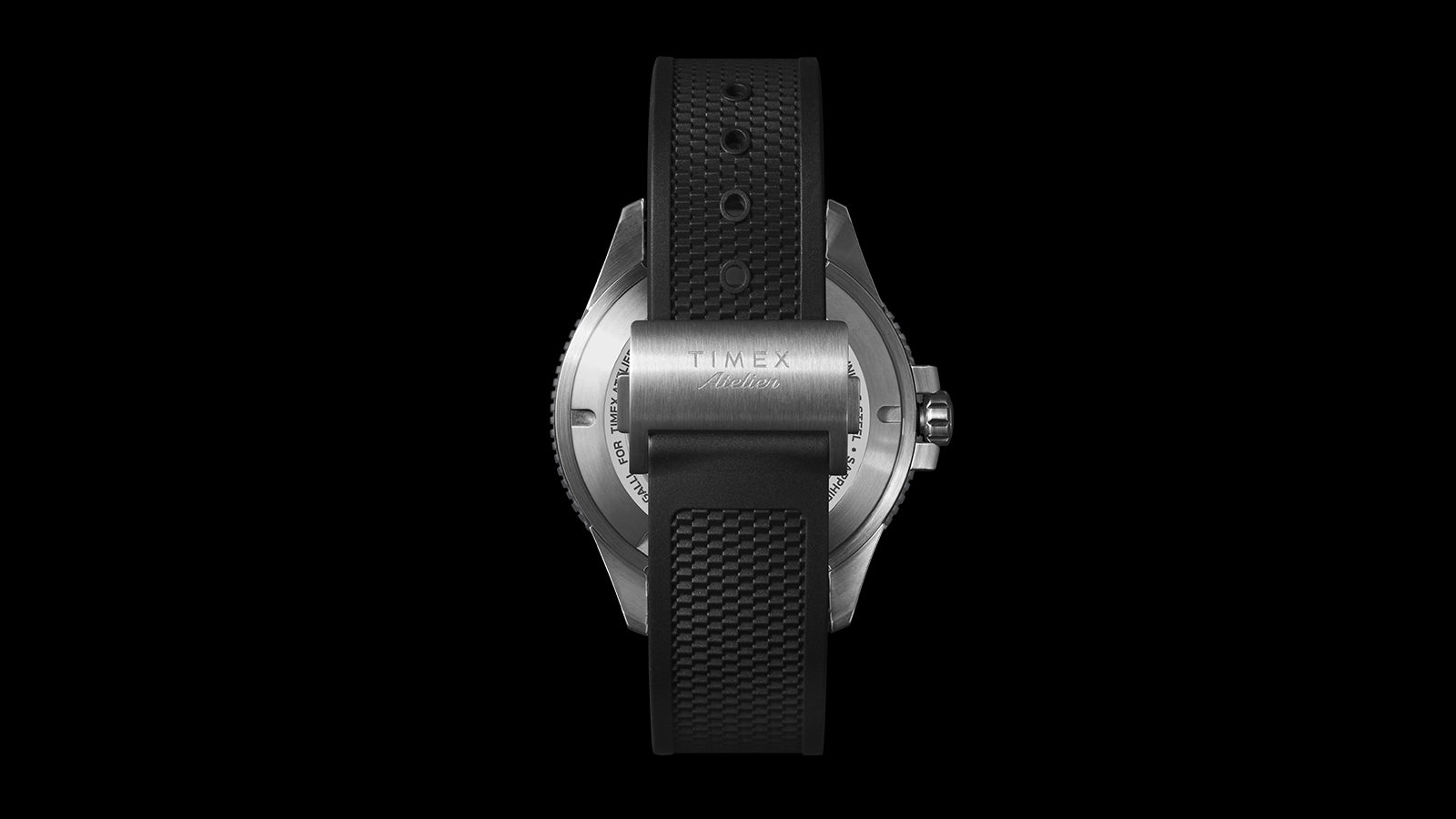 “Rear view of the Timex Atelier automatic watch with a black textured rubber strap and stainless steel buckle engraved with the Timex Atelier logo.