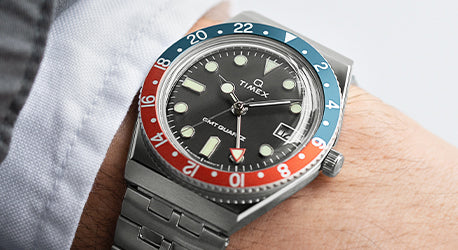 Q Timex GMT in stainless steel bracelet on a man's wrist