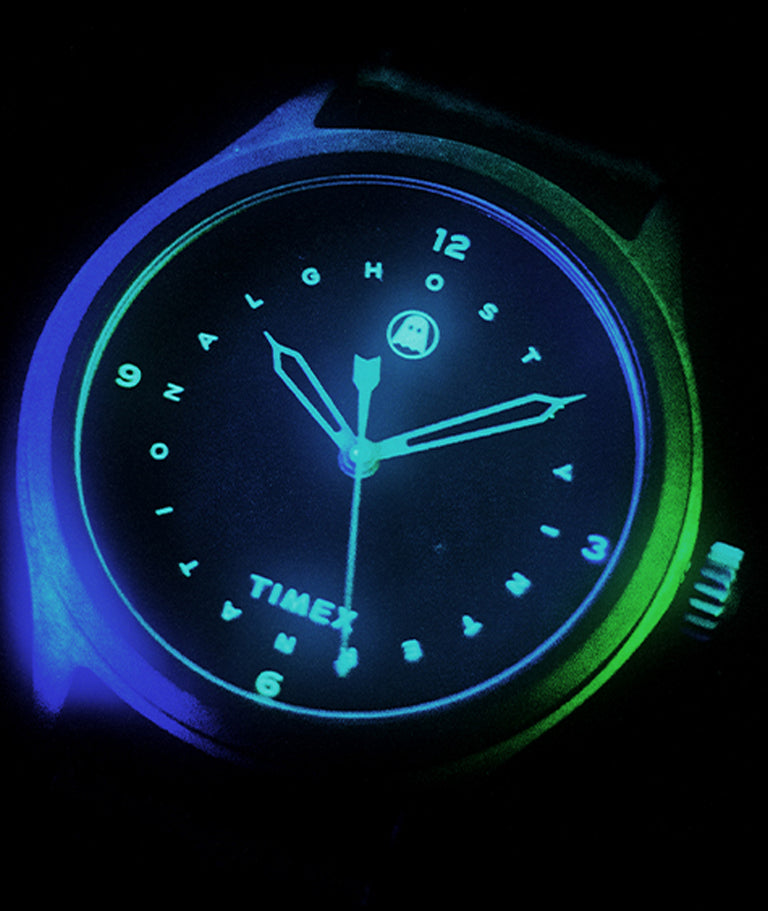 Up close of analog watch with the indiglo dial activated