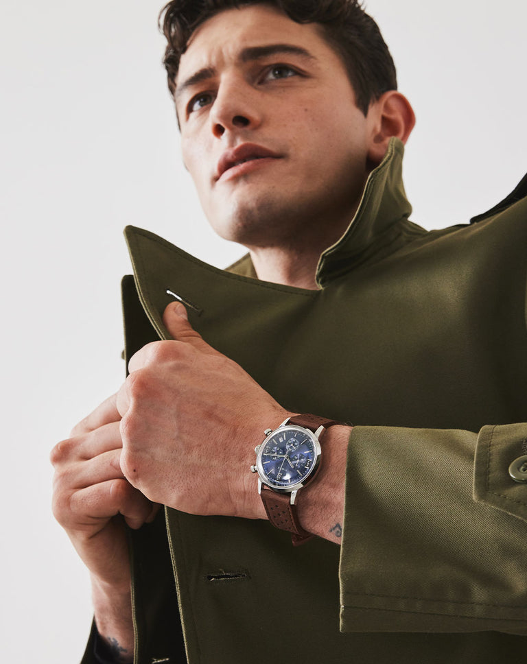 Man wearing our best selling Marlin Automatic Tachymeter watch featuring a blue dial and brown leather strap