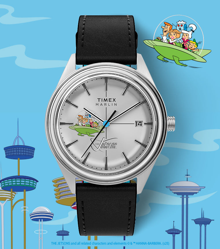 A Timex Marlin wristwatch featuring The Jetsons on the dial. The silver watch with a black leather strap shows George, Jane, Judy, Elroy, and Astro in their green flying car. The background includes a futuristic Jetsons-style cityscape with tall buildings and the family flying in their spacecraft.