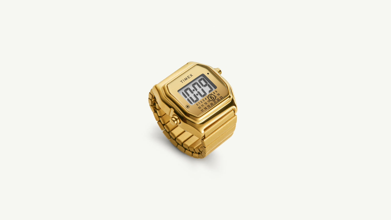 Angled view of the gold Timex x MM6 Maison Margiela T80 watch ring showing its bold digital display and polished metal bracelet design, photographed on a white background to highlight its sculptural form.