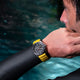 Diver wearing the Timex Deepwater Reef 200 with yellow strap, adjusting gear near the water’s surface, emphasizing sporty style and professional performance.