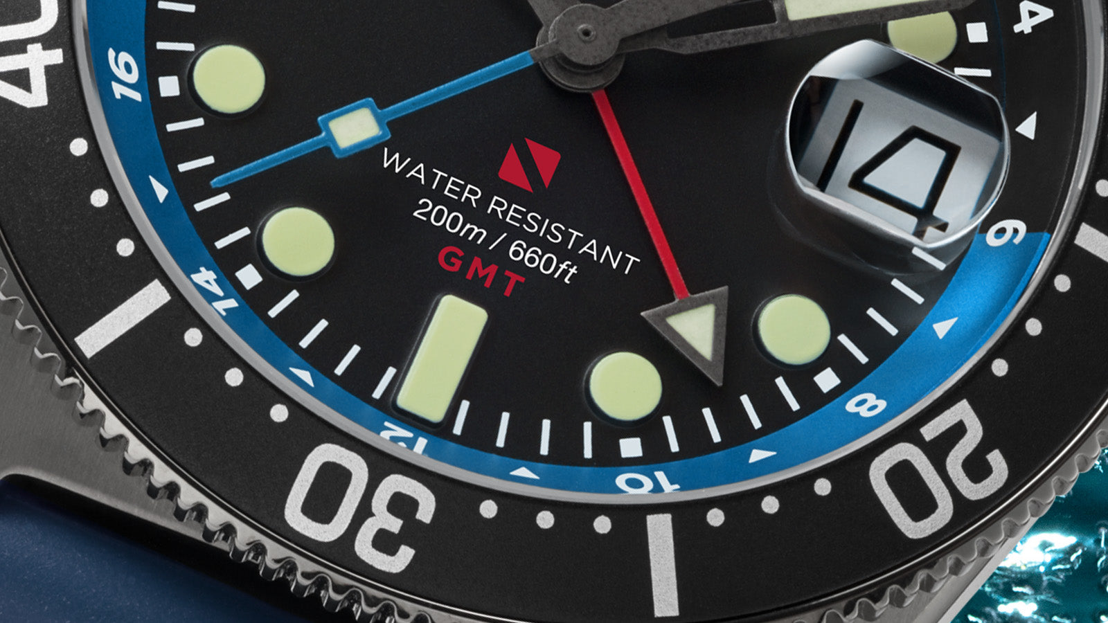 Macro close-up of the Timex Deepwater Reef 200 GMT dial highlighting the blue GMT hand, red “Water Resistant 200m / 660ft” text, and detailed bezel engravings.