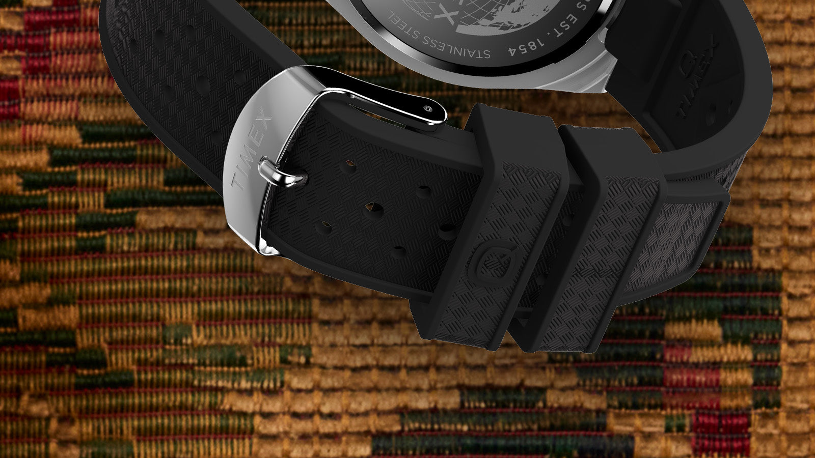 Close-up of the Q Timex® Continental GMT highlighting the textured rubber strap, stainless-steel buckle, and precision-crafted case finishing.