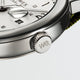 Close-up of the Timex Weekender’s crown engraved with “we.” next to the white dial and date window.