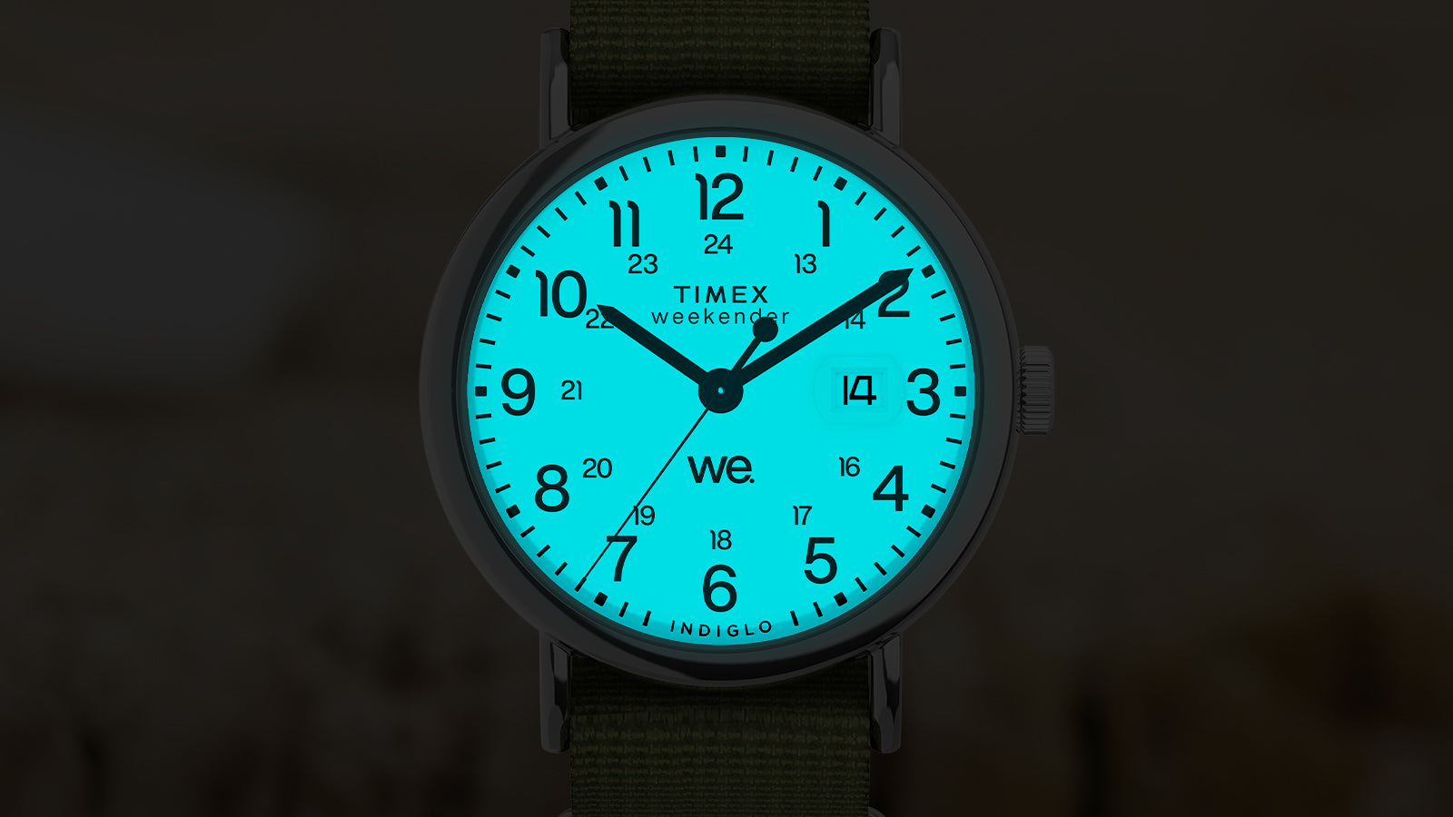 Timex Weekender dial glowing with Indiglo backlight, illuminating the numerals and date window in blue.