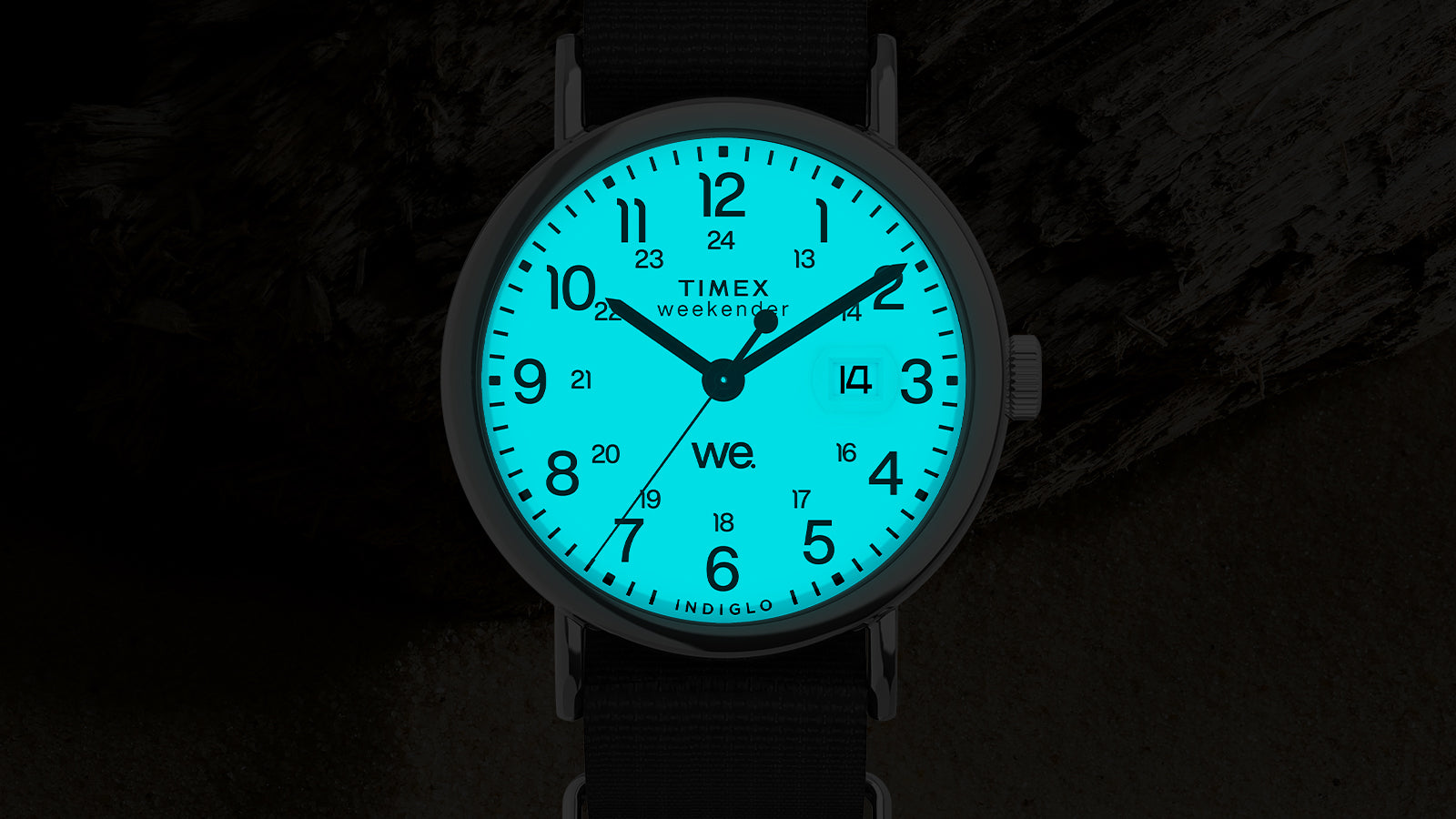 Timex Weekender dial glowing with Indiglo backlight in blue, showing luminous numerals and date window.