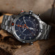 Detailed close-up of the Timex Expedition Tide-Temp-Compass resting on a wooden surface, highlighting the textured dial, compass bezel with cardinal points, and bold orange hands.