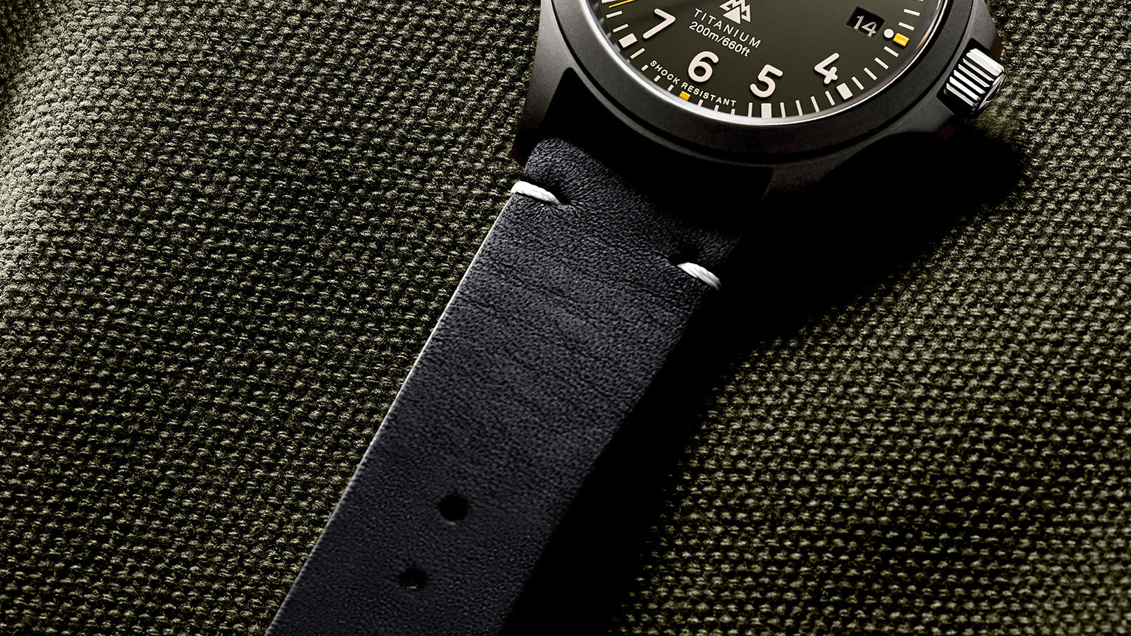 Close-up of the Timex Expedition Titanium’s black leather strap with white stitching, highlighting durability and clean stitching against a fabric background.