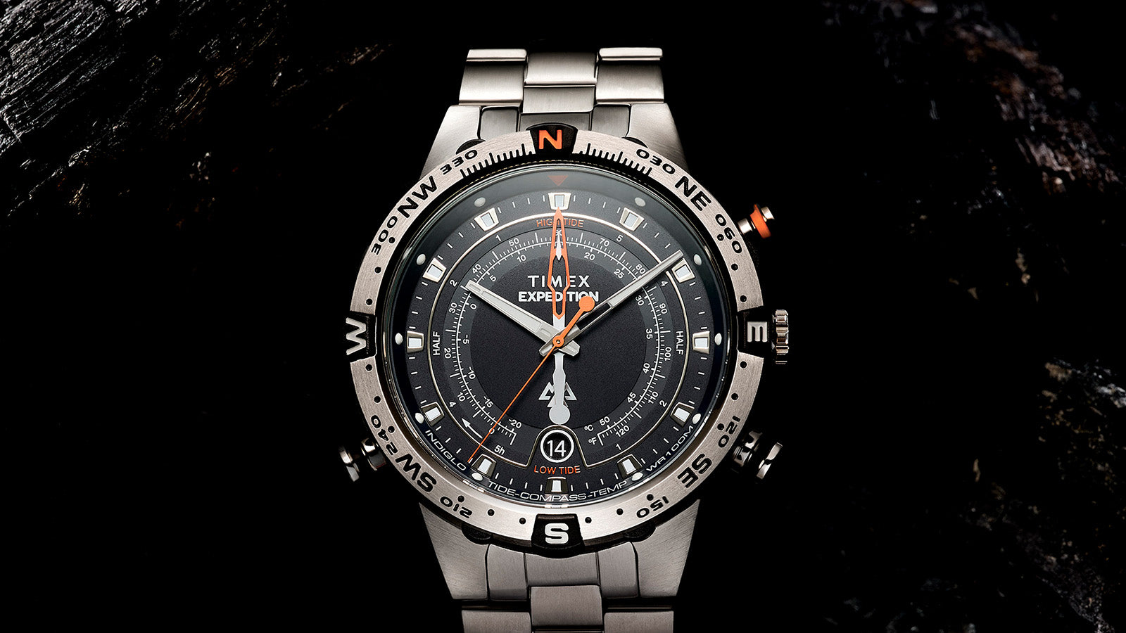 Timex Expedition Tide-Temp-Compass photographed head-on against a black background, emphasizing the full dial layout, compass bezel, and luminous markers.