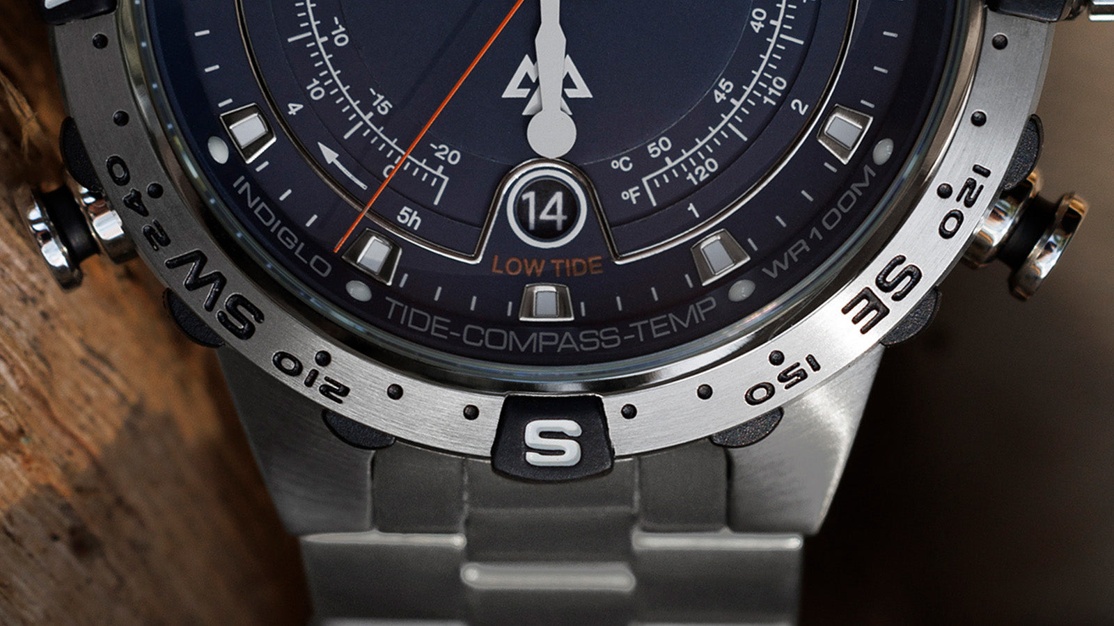 Close-up of the lower part of the Timex Expedition Tide-Temp-Compass bezel and dial, highlighting the “Low Tide” indicator, compass markings, and brushed stainless-steel bracelet links.