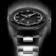 Front view of Timex Atelier automatic dive watch showing black dial, bold luminous indices, stainless steel bracelet, and engraved bezel detail.