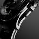 Macro side view of Timex Atelier watch case with brushed stainless steel finish, detailed crown engraved with "T" logo, and knurled bezel edge.