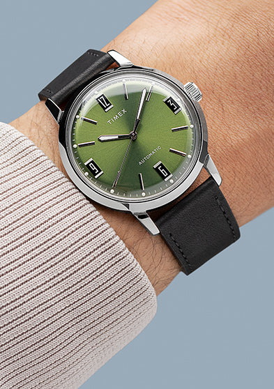 Timex Marlin Automatic worn on wrist, featuring elegant green dial, polished silver case, and black leather strap.