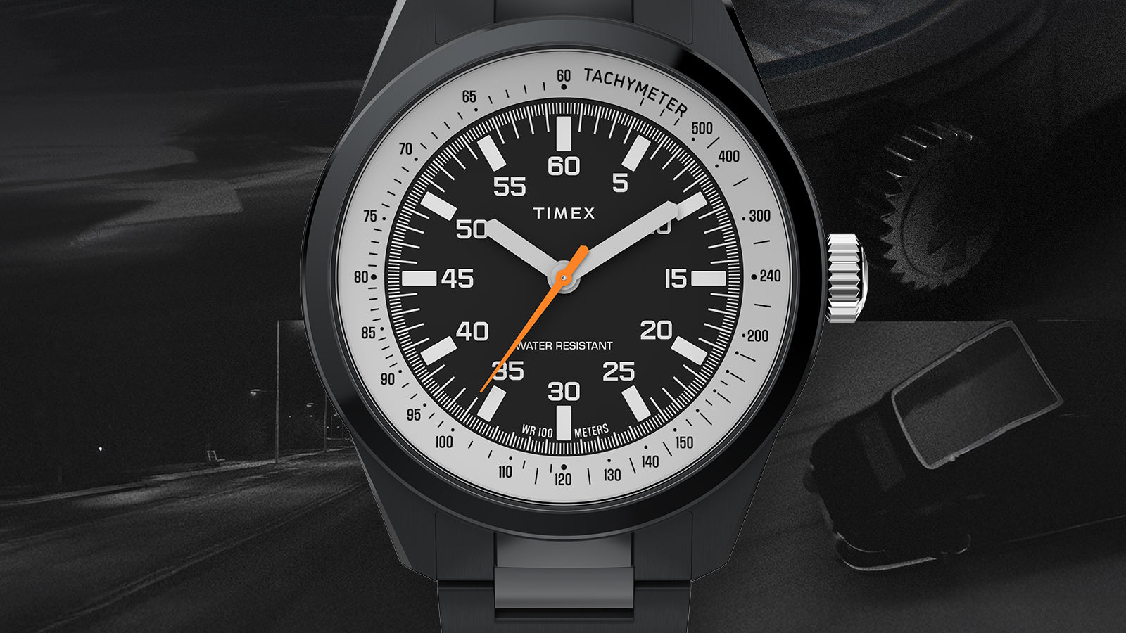 A centered close-up of the Huckberry x Timex 1979 Black Max watch face, highlighting the tachymeter ring, bold white dial markings, and orange seconds hand against a dark background.