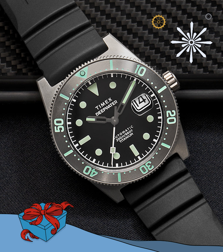 Timex Deepwater Reef automatic dive watch with a black dial, luminous hour markers, date window, and titanium case, shown on a black rubber strap against a textured dark background with subtle holiday graphic accents.