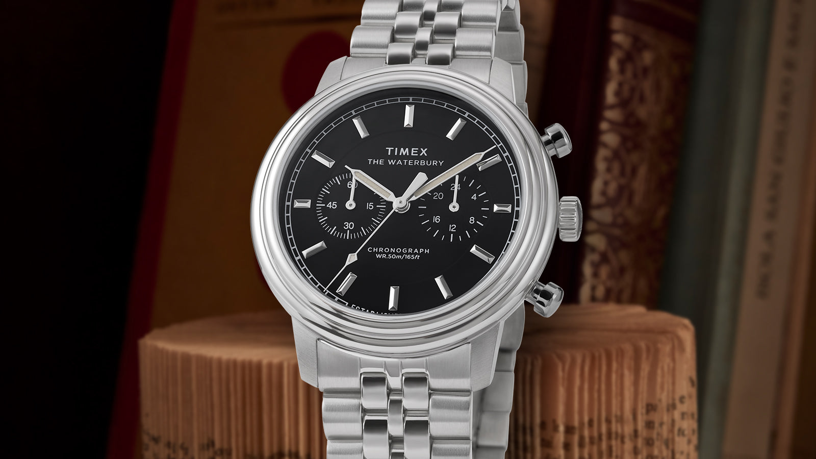 Front-facing view of the Timex Waterbury Metropolitan Chronograph showing polished stainless steel bracelet, black dial, and three-hand chronograph layout.