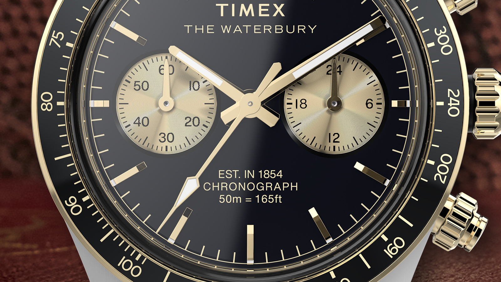 Close-up of the Timex Waterbury Heritage Chronograph dial highlighting gold sub-dials, tachymeter bezel, and luminous hands.