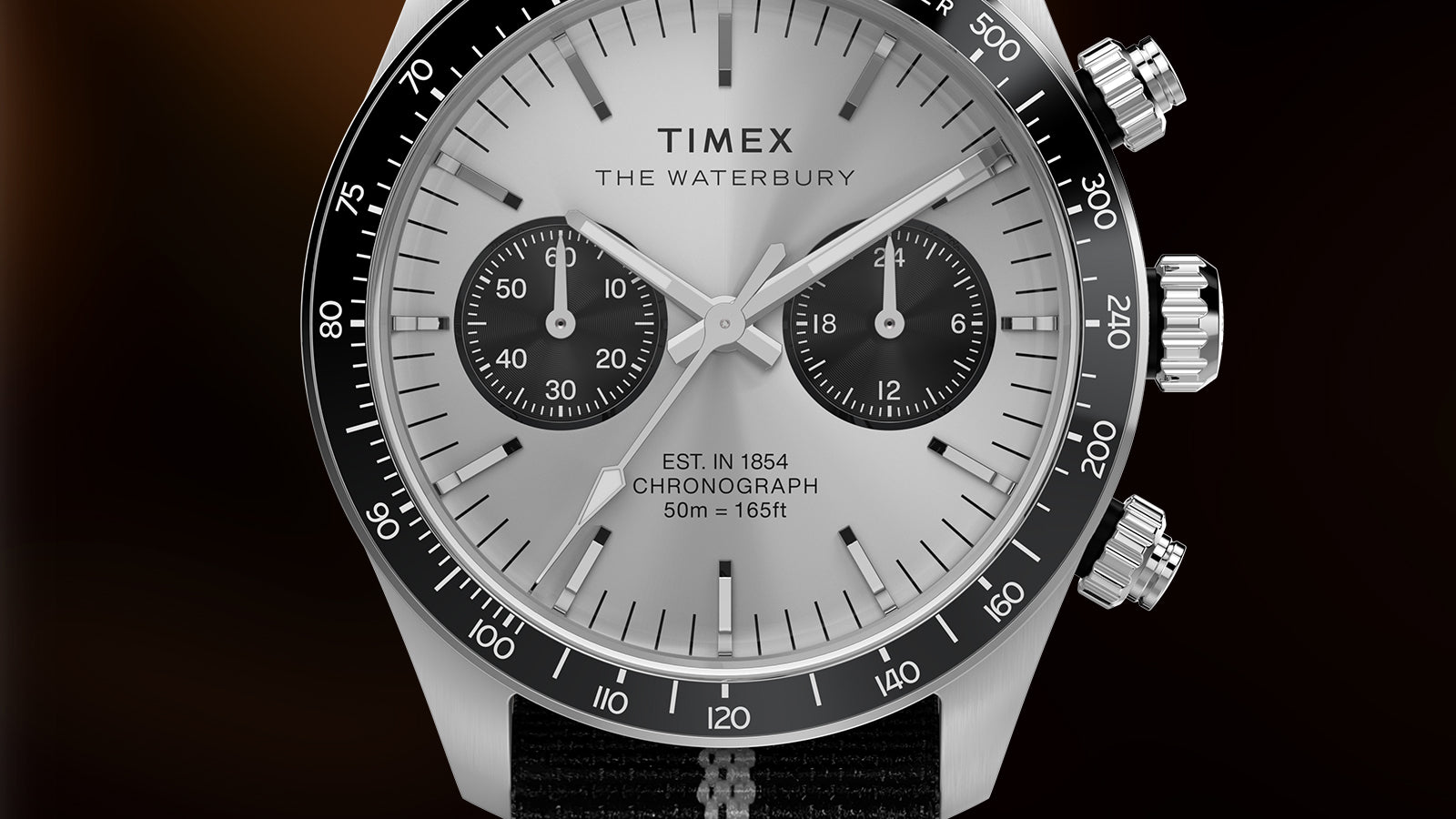 Macro close-up of the Timex Waterbury Heritage Chronograph dial with black tachymeter bezel, silver face, and contrasting black chronograph sub-dials.