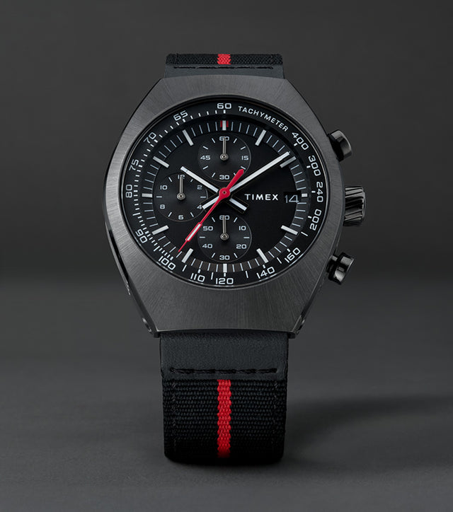 Front view of the Timex Legacy Tonneau Chronograph showing black dial with white markers, red seconds hand, and tachymeter scale.