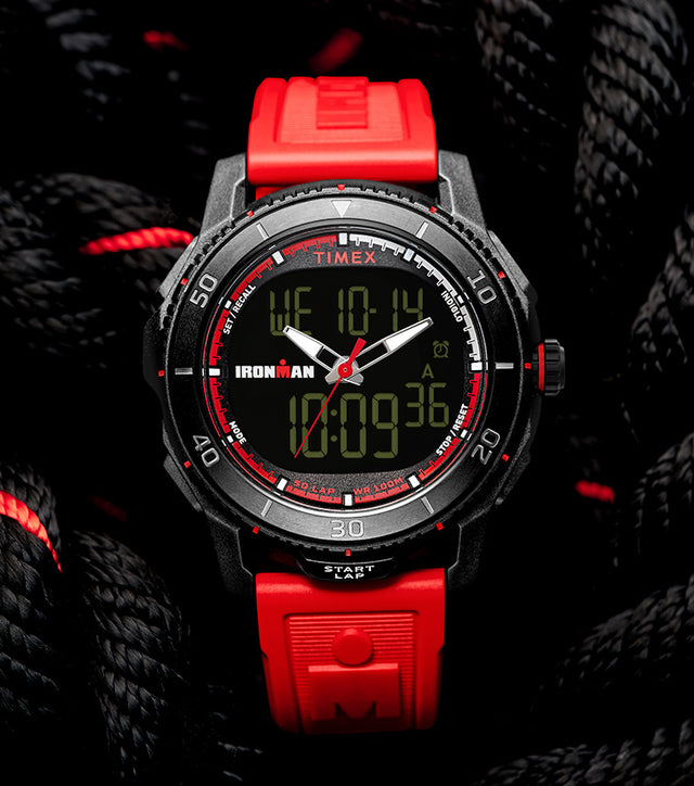 TIMEX® IRONMAN® Adrenaline Ana-Digi watch with black case, red accents, and red resin strap displayed on coiled black rope with red details.