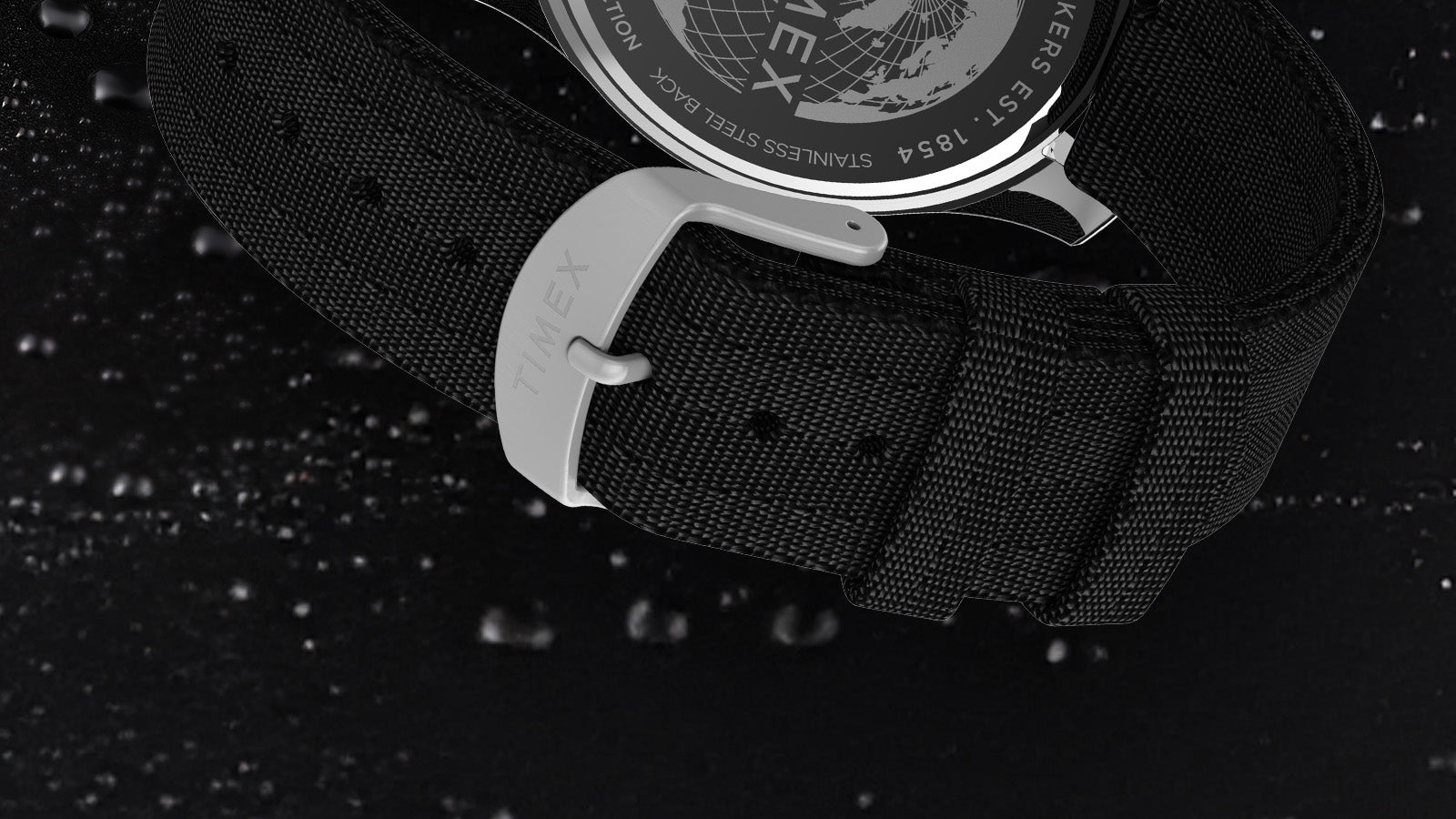 Close-up of the black fabric strap and stainless steel buckle engraved with “Timex” on the Harborside Coast watch.