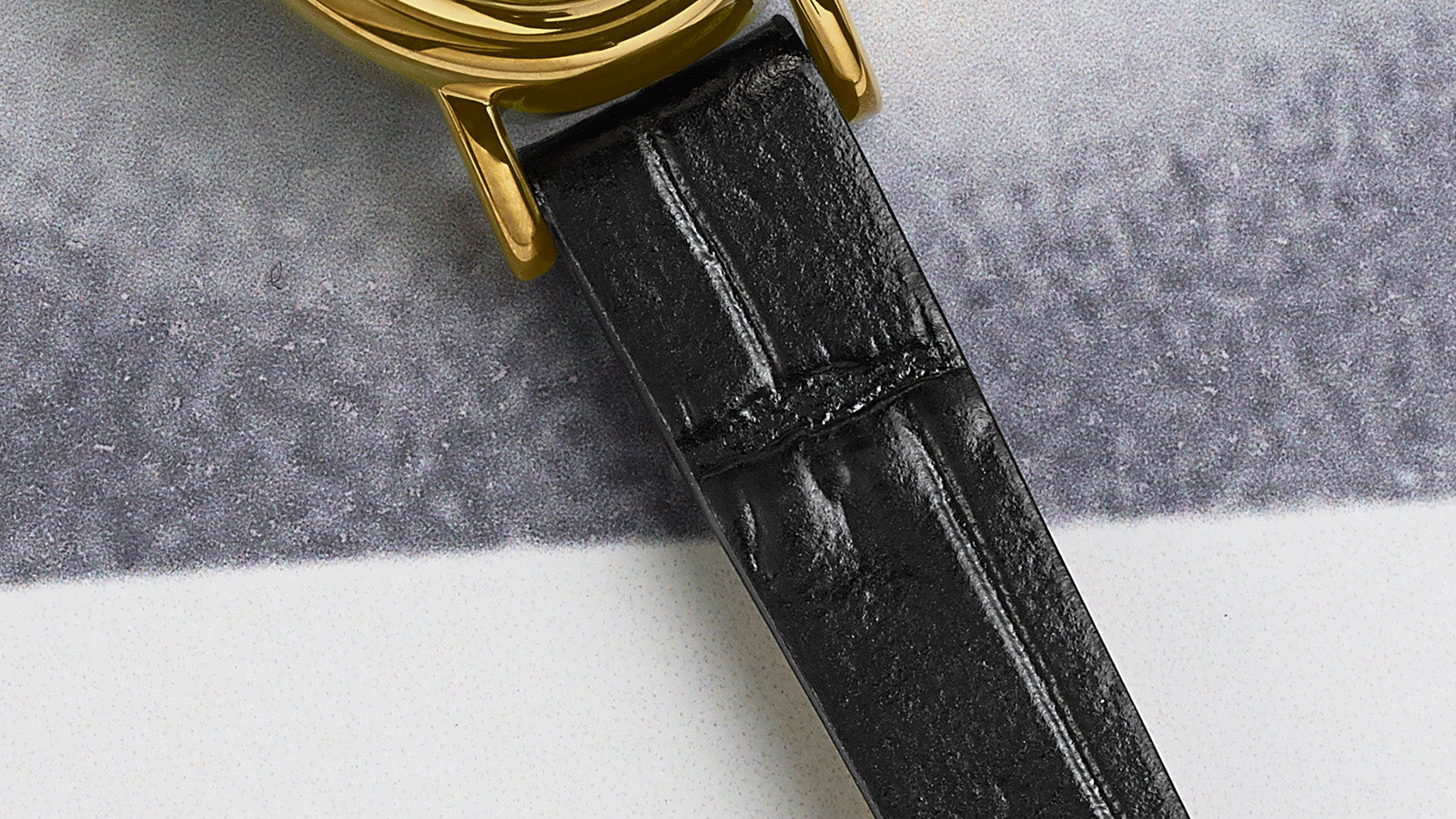 Close-up of the black crocodile-pattern leather strap attached to the gold-tone case of the TIMEX® Cavatina watch.