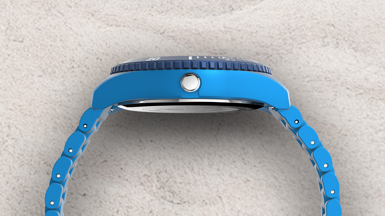 Side view of the TIMEX® Legacy Ocean #tide watch showing the blue case, crown, and bracelet links, displayed on sand.