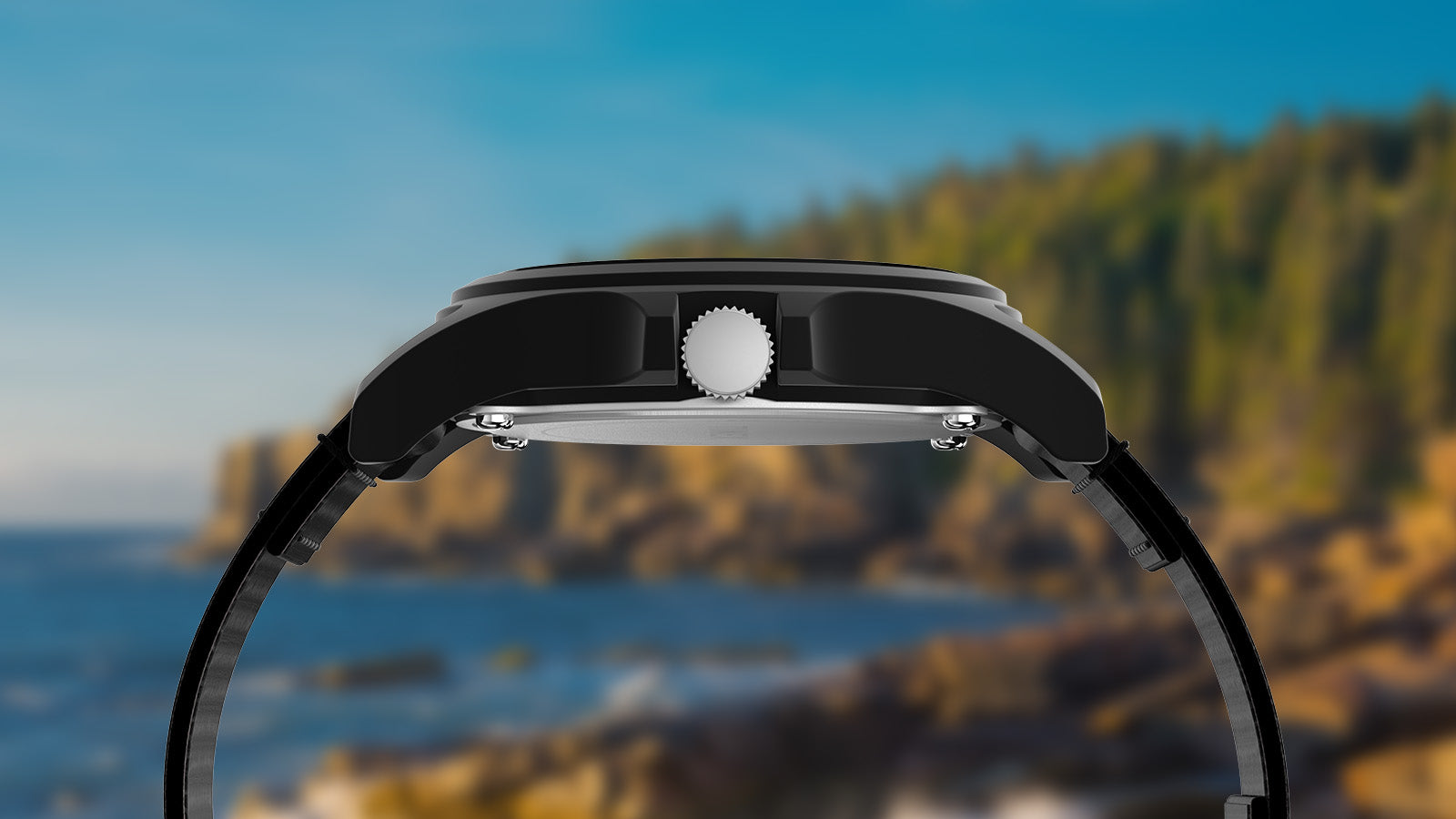 Side profile view of the Timex Acadia National Park watch, highlighting the black matte case and crown with the ocean and rocky cliffs in the background.