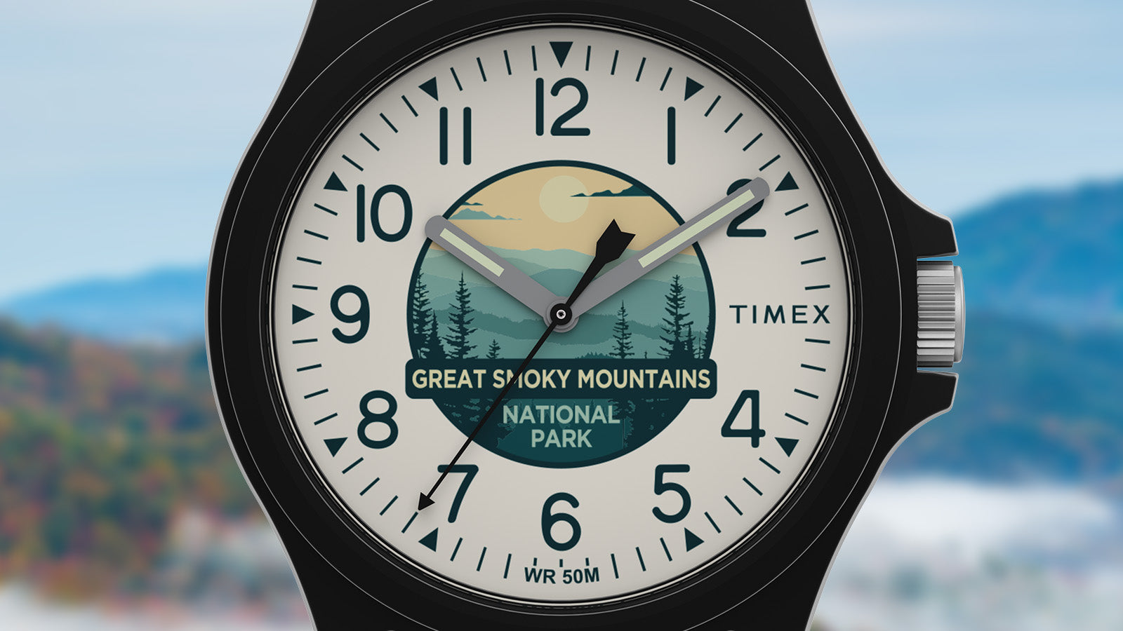 Close-up of the Timex Great Smoky Mountains National Park watch face, showcasing a nature-inspired dial design with mountains, trees, and a rising sun.