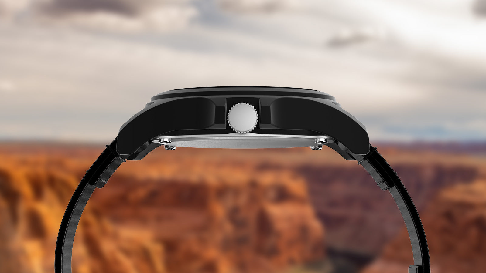 Side profile of the Timex Grand Canyon National Park watch, showing its matte black case and crown with the canyon’s red rock landscape in the background.