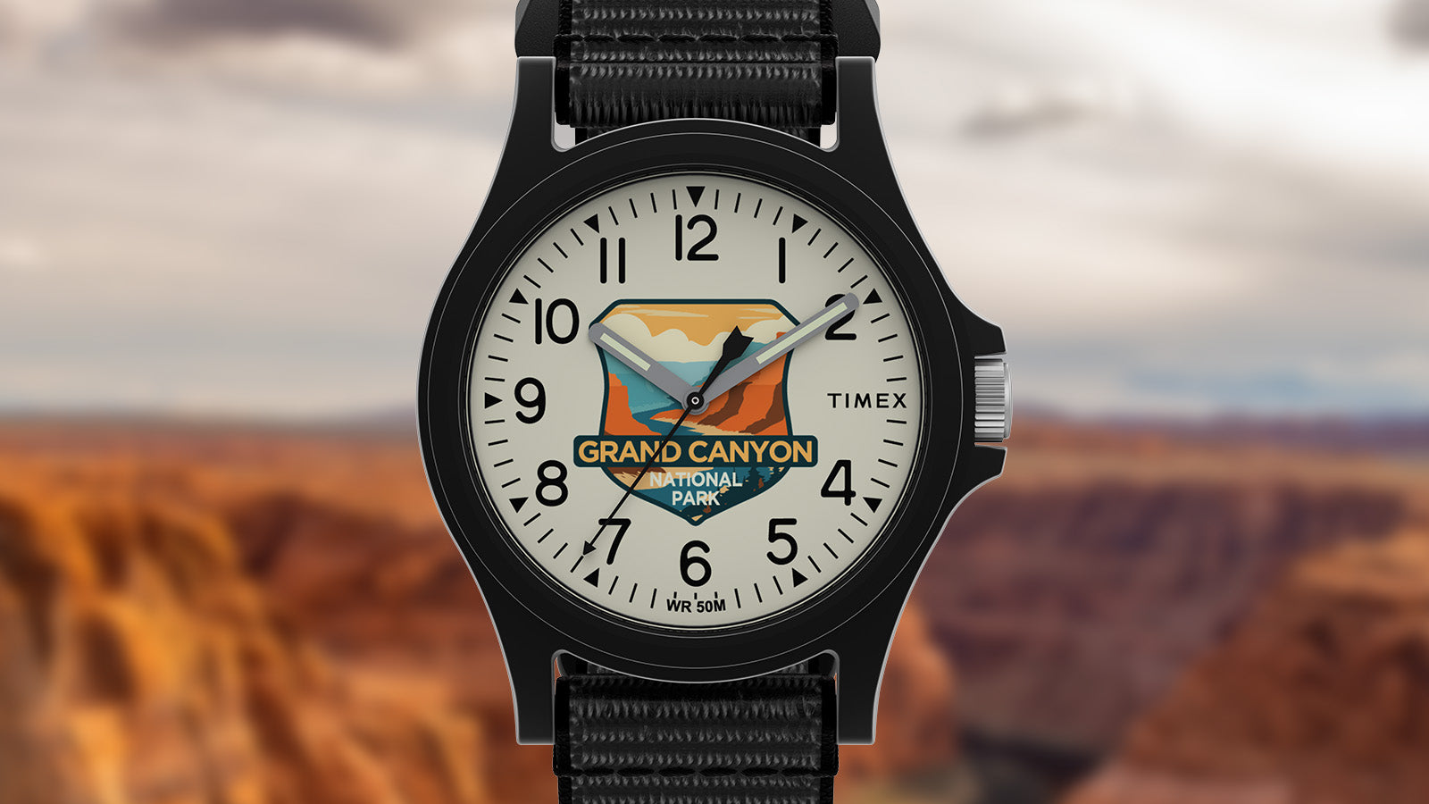 Front view of the Timex Grand Canyon National Park watch with desert-inspired dial artwork and black strap, set against the rugged canyon landscape.