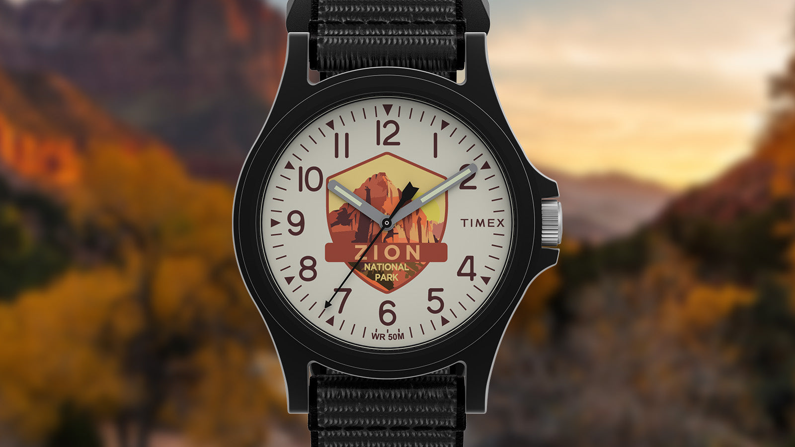 Close-up of the Timex Zion National Park watch face featuring canyon artwork in warm tones of red and orange with bold numerals and luminous hands.