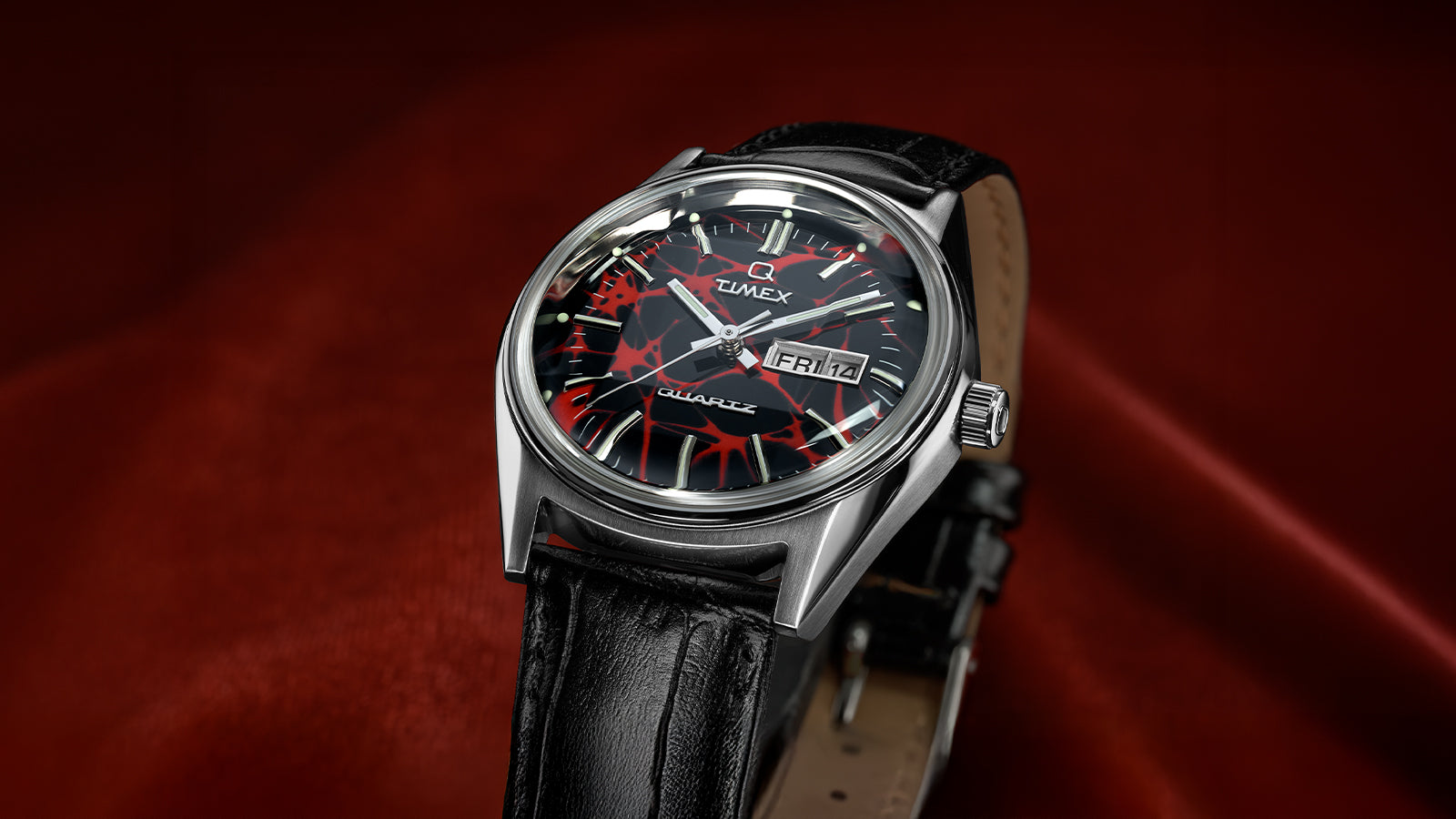 Angled view of the Q Timex® Red Vega 1978 Reissue watch with stainless steel case, domed crystal, and red and black dial.