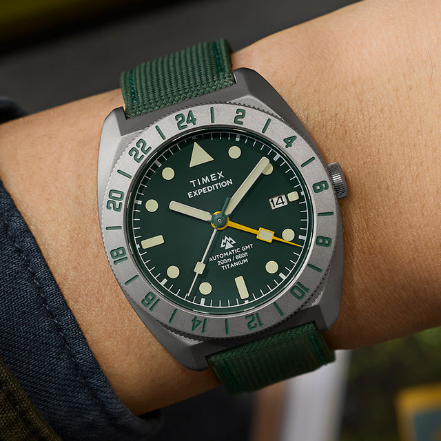Timex Expedition Pioneer Titanium Automatic GMT watch worn on wrist with green fabric strap and bold outdoor styling.