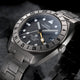 Close-up angled view of the Expedition® Pioneer Titanium Automatic GMT highlighting the black dial, luminous hour markers, date window, and yellow GMT hand.