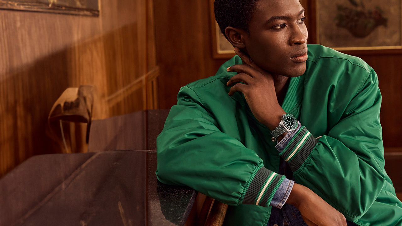 Man wearing Timex Waterbury Heritage Automatic GMT watch with stainless steel bracelet and black dial.