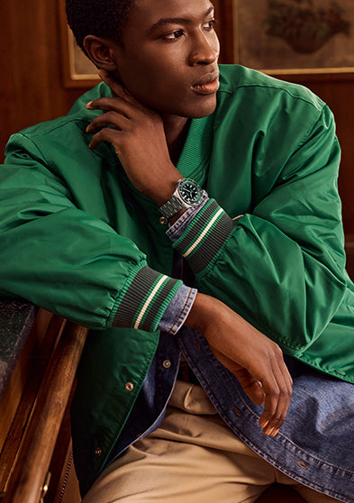 Man wearing Timex Waterbury Heritage Automatic GMT watch with stainless steel bracelet and black dial.