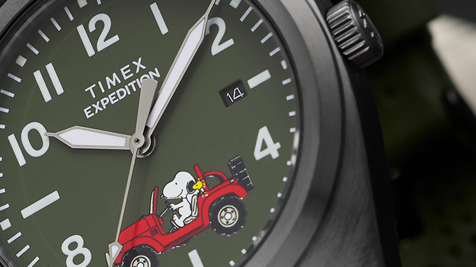 Macro detail of Timex Expedition Snoopy Road Trip dial showing white Arabic numerals, date window, and Snoopy driving a red Jeep with Woodstock.