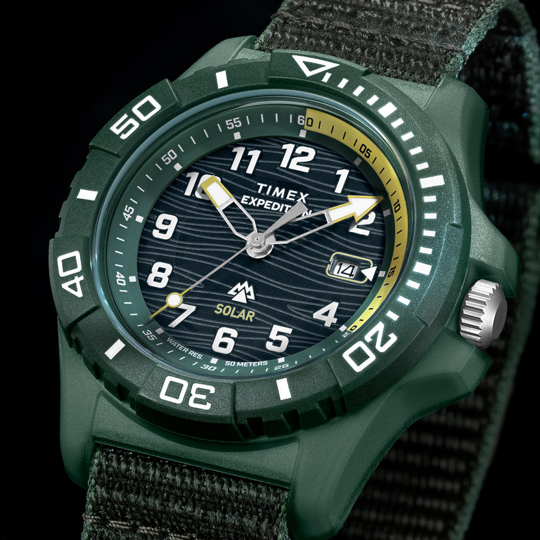 Timex Expedition® Freedive Solar watch with green resin case, black dial, yellow accents, and 50-meter water resistance on dark background.